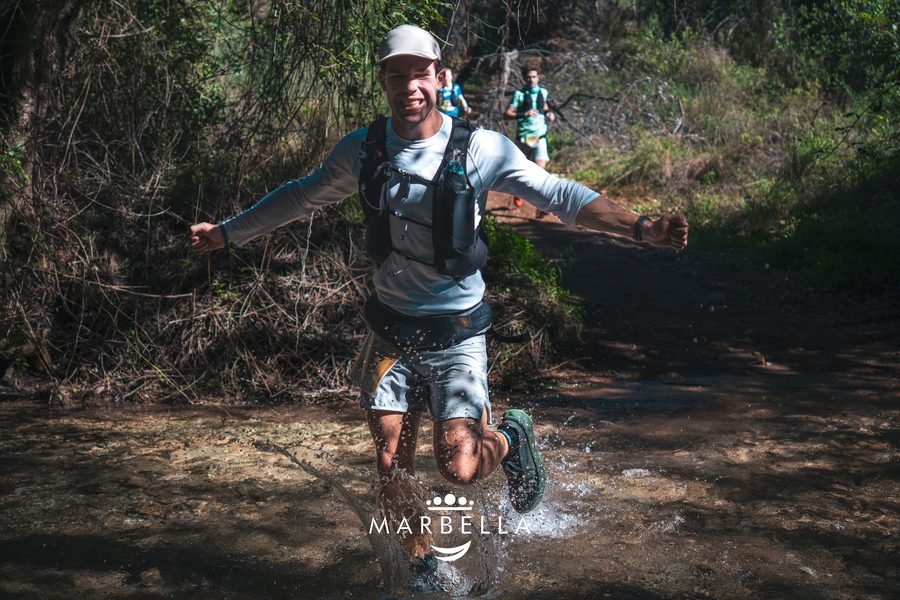Corredor cruzando un arroyo en Sierra Blanca Trail